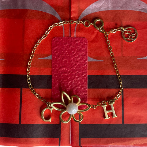 * Pulsera Carolina Herrera Flor Perla Dorado.